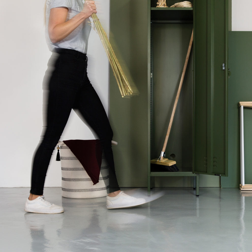 person walking past dark olive steel locker
